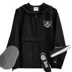A black packable jacket with embroidered 'C' logo on the left sleeve, a hood, front kangaroo pocket, and a zipped pouch pocket. It is displayed alongside a grey hat and black sneakers.