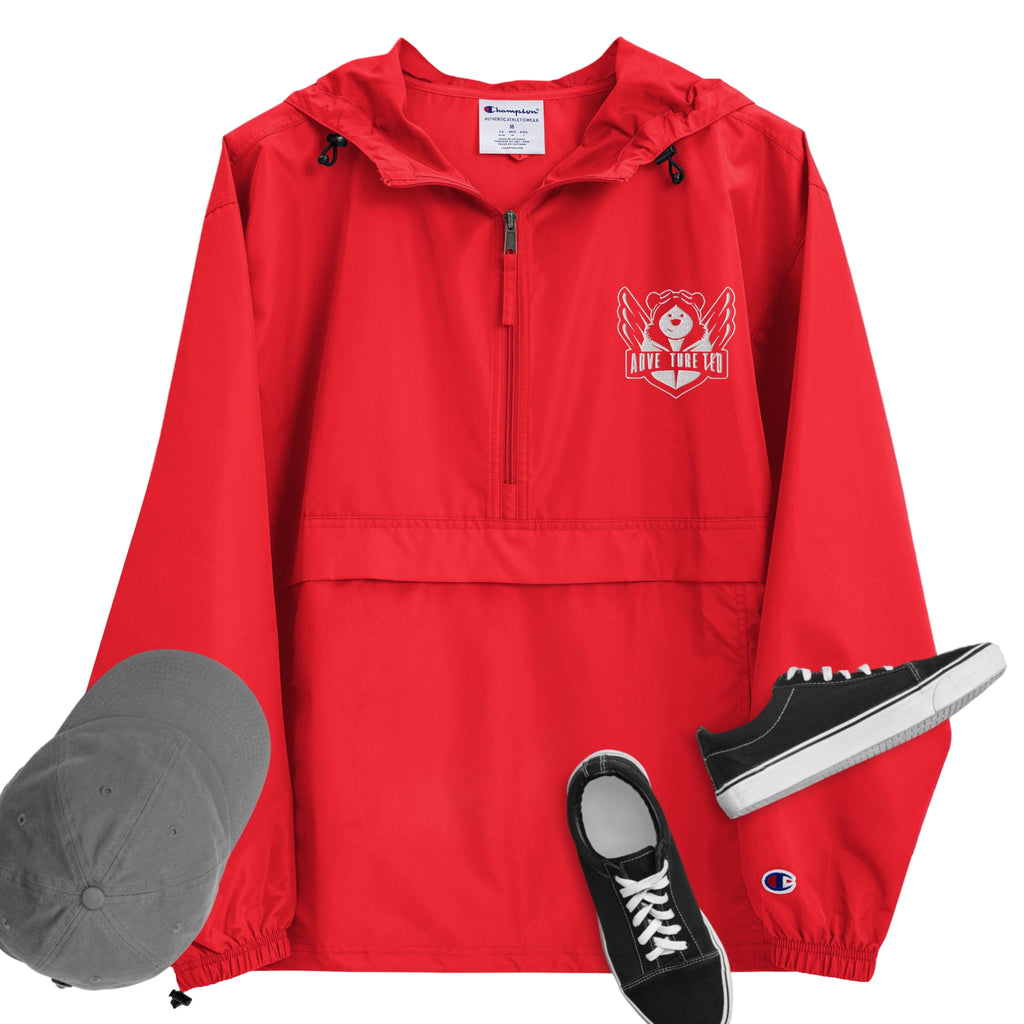 A scarlet red packable jacket with embroidered 'C' logo on the left sleeve, a hood, front kangaroo pocket, and a zipped pouch pocket. It is displayed alongside a grey hat and black sneakers.