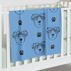 Light blue jersey blanket with paw prints and outline of adventure ted face. 